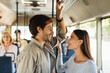 © Prostock-studio - Happy smiling couple standing in bus and talking
