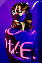 Young Woman In Projector Lights With Led Futuristic Glasses