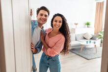 Cheerful couple inviting people to enter home