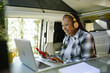 © Gabriel Trujillo - Happy black woman working remotely in caravan