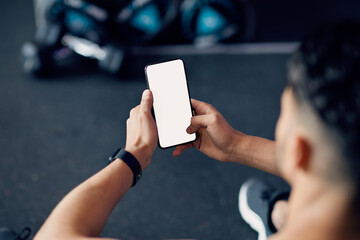 Wall Mural - Mockup Image Of Young Athlete Man Using Blank Smartphone In Gym