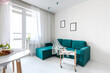 © Полина Власова - Minimalistic interior design studio apartment with white walls and a turquoise green sofa. Living room and dining room for a comfortable life