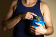 © Narayan - man caring for a potted plant for decoration, indoor plant concept