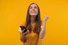 Euphoric Footbal Fan Girl Celebrating Her Favourite Team Victory And Money Win After Betting At Bookmaker's Mobile Application, Making Winner's Gesture  Yes Clenching Her Fist