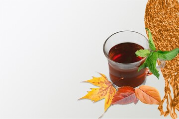 Wall Mural - Warm knitted scarf and a cup of tea with autumn leaves