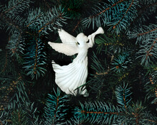White Angel With Trumpet On Evergreen Tree Branches Creative Layout. Christmas Minimal Background Concept. Flat Lay.