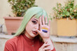 © Cavan Images - Person with green hair shows non-binary flag in the palm of her hand