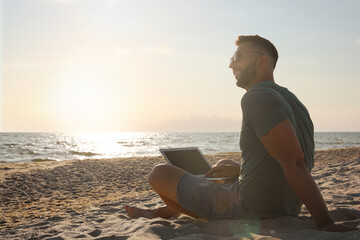 Sticker - Man working with laptop on beach. Space for text