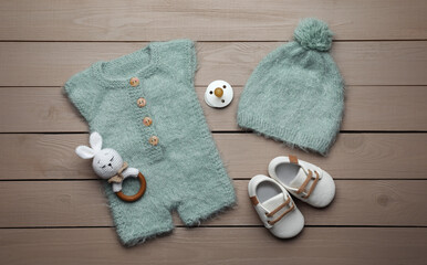 Wall Mural - Flat lay composition with cute baby knitwear for photoshoot on wooden background