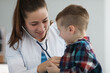 © H_Ko - Young woman pediatrician listen kid with stethoscope tool on planned checkup