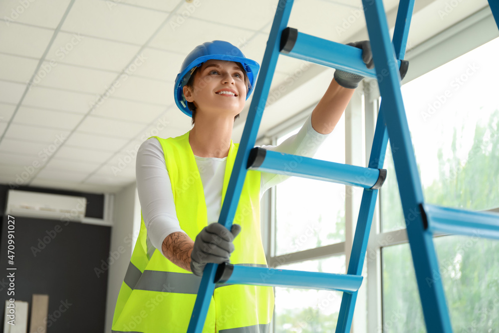 Female construction worker near ladder in room