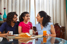 Family Sharing An Intimate Moment At The Breakfast Table In The Moring At Home