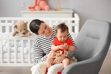 Poster - Young mother with her little baby and toys in bedroom