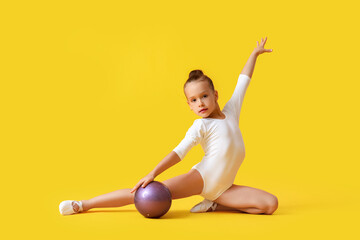 Wall Mural - Little girl doing gymnastics with ball on color background