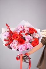 Beautiful bouquet of mixed flowers in woman hand. Handsome fresh bouquet. Small flower shop and Flowers delivery.