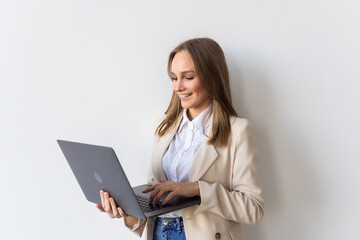 Portrait of young businesswoman holding laptop in the office isolated over white background