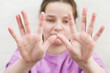 © Sergei - Teenage girl looks at her hands. Selective focusing on the palms. The girl's face is out of focus.