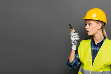 Blonde Builder In Glove And Safety Vest Using Walkie Talkie Isolated On Grey