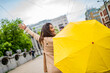 Woman looking away using umbrella outdoors. Woman Walking with Umbrella. Waiting for bus. Woman with umbrella walking down the street. Beautiful woman with umbrella on a rainy day.