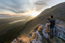 View Of A Person Standing On The Rocks Taking Photos From Mountain Top At Matese Lake, Campania, Italy.