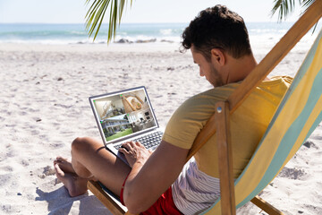 Sticker - Caucasian man on holidays using laptop with views of home from security cameras on screen