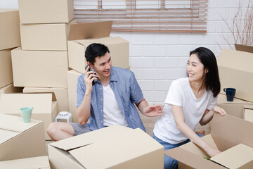 Asian couple doing online business together at home. Helping to pack products into cardboard boxes. family concept, modern business, small entrepreneurs, online delivery