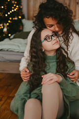 Happy young woman with cute teenage daughter in christmas interior.