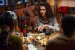 © AnnaStills - Young woman sitting at the table eating salad and talking to her friends