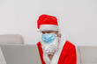 © chechotkin - man dressed as Santa Claus with laptop