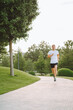 © Olga Rolencino - Attractive young man athlete wearing sportswear run in modern park at summer morning. Morning jogging, cardio, weight loss