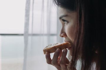 Asian woman eat bread with sweetened condensed milk as easy breakfast.