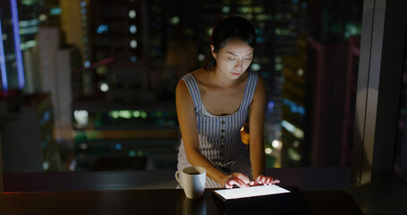 Wall Mural - Woman work on tablet computer at room in the evening