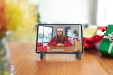 Happy Caucasian Woman In Santa Hat Smiling On Tablet Video Call Screen At Christmas Time