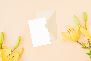 Wall Mural - mockup white wedding invitation and envelope with yellow lilies on color background