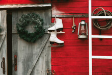 Barn Of The House Decorated For Christmas With Light Bulbs, Wreaths, Skates And Garlands