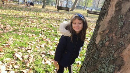 Wall Mural - Happy little girl fun in autumn park. Sunny day . Cheerful child in nature.	