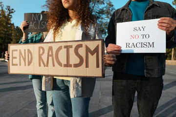 Wall Mural - Group of people holding signs outdoors, closeup. Racism concept