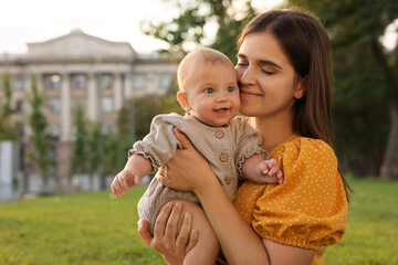 Wall Mural - Happy mother with adorable baby walking in park on sunny day, space for text