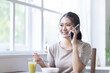© milatas - 朝食を食べながら電話をする女性