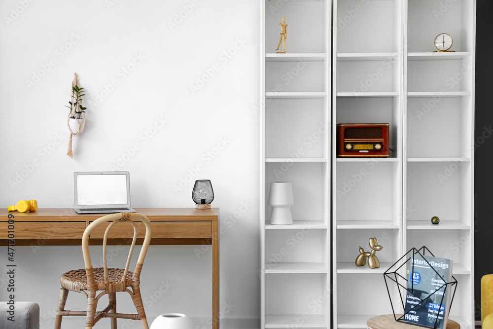 Interior of modern room with shelf unit and workplace