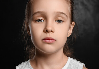 Portrait of cute little girl on black background, closeup