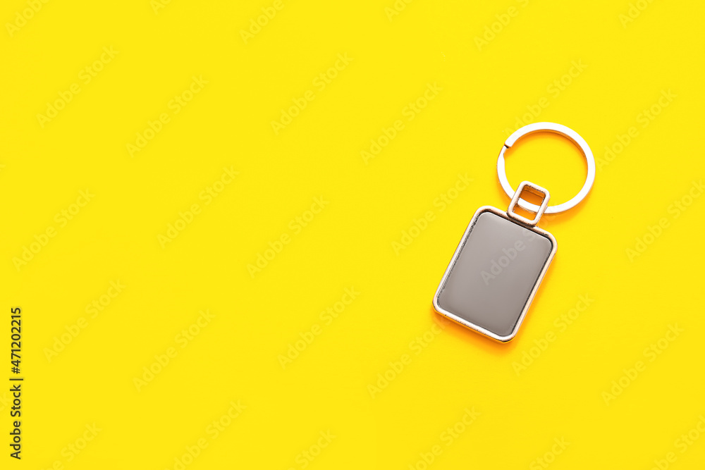 Stylish square keychain on yellow background
