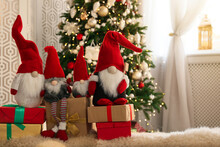 Cute Christmas Gnomes And Gift Boxes On Carpet In Room