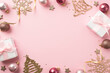 © ActionGP - Top view photo of christmas decorations pink balls gold bell pine snowflake shaped ornaments white gift boxes stars serpentine sequins on isolated pastel pink background with copyspace mock up
