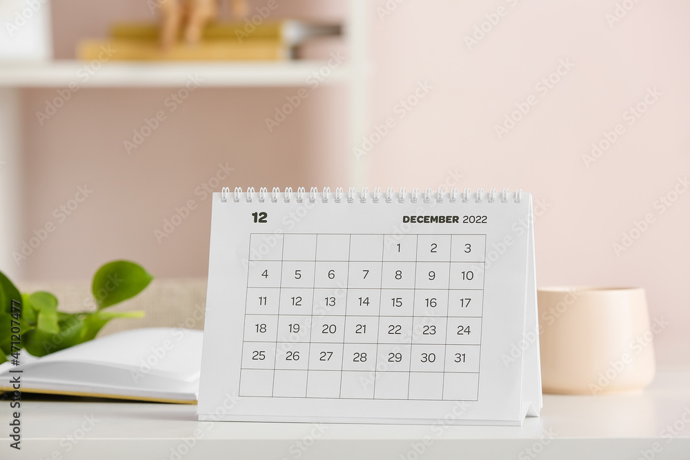 Paper calendar for December 2022 on table