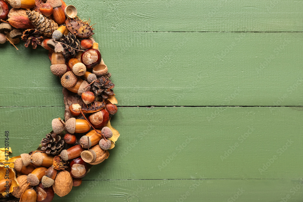 Beautiful acorn wreath on green wooden background