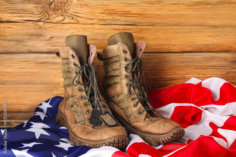 Military boots, tags and USA flag on wooden background