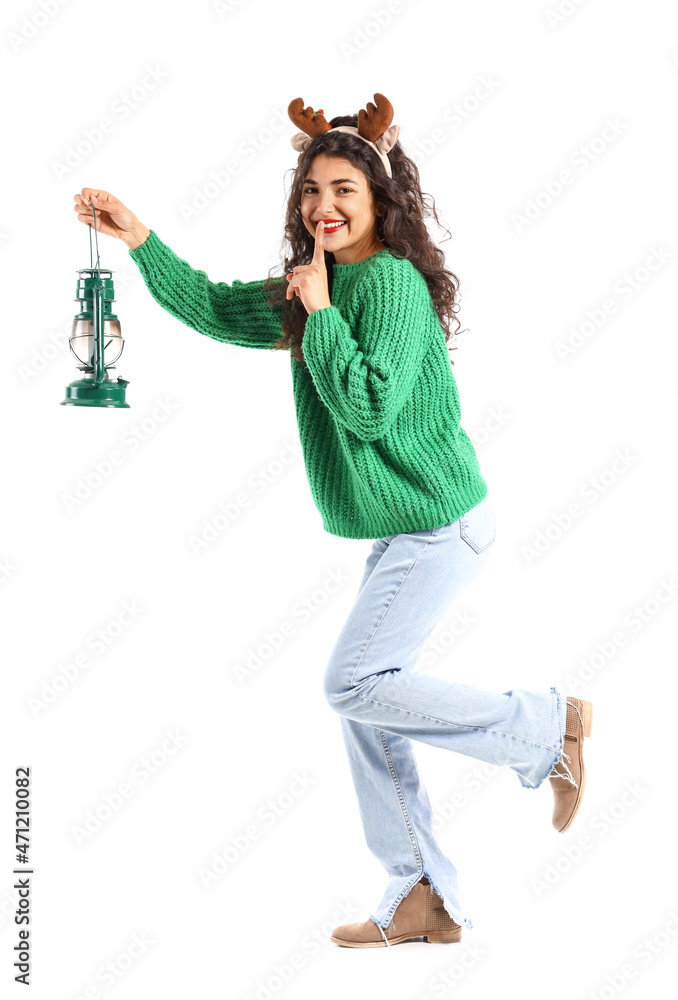 Beautiful walking young woman with lantern showing silence gesture on white background