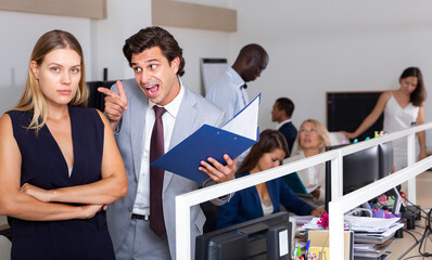 Wall Mural - Male angry boss blaming young woman office worker in office