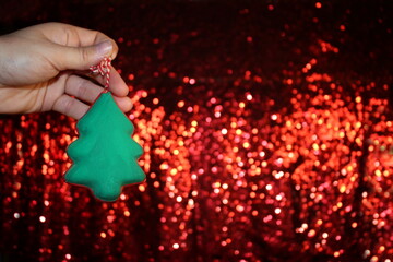 Wall Mural - beautiful green Christmas tree is lying on your hand on a shiny background